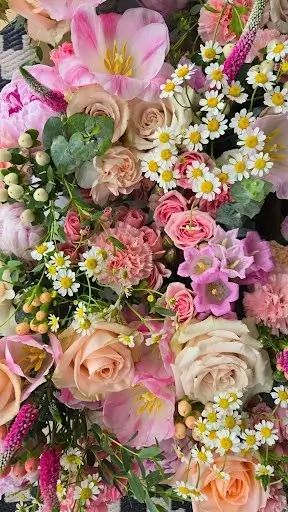 Close-up of pink roses, tulips, chamomile and hypericum berries